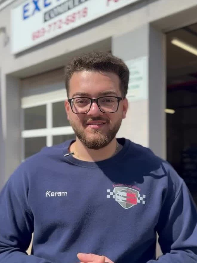 Karam, the owner of Exeter Auto Clinic, in front of the shop bays.